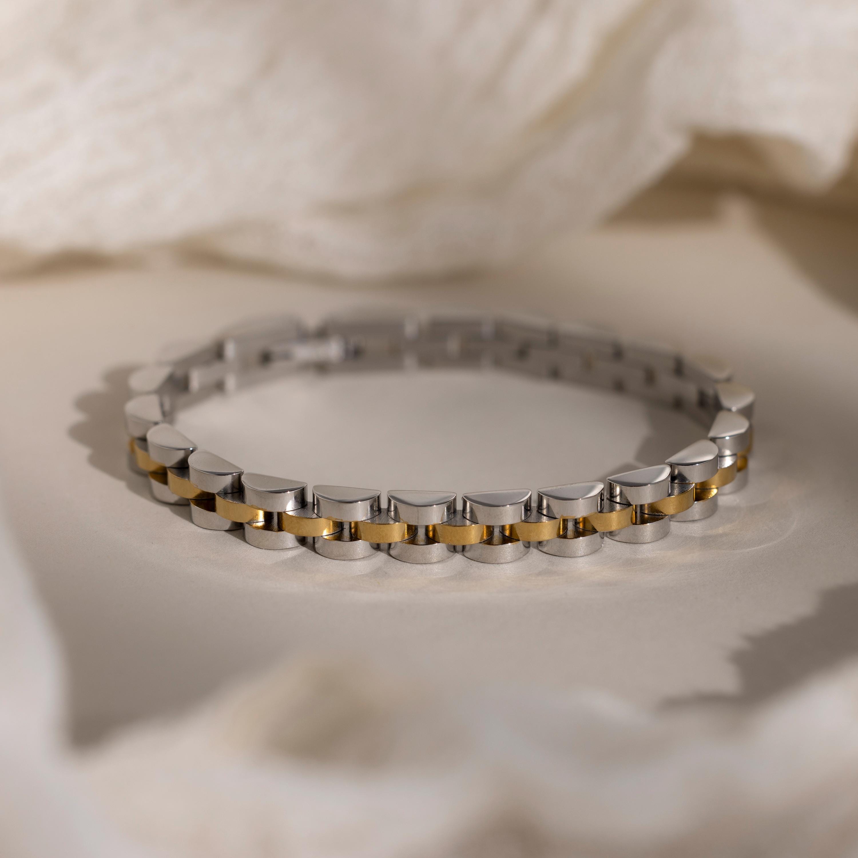 The Mixed Metal Link Bracelet in silver and gold is displayed on a soft, neutral background—an elegant and timeless gift for him.