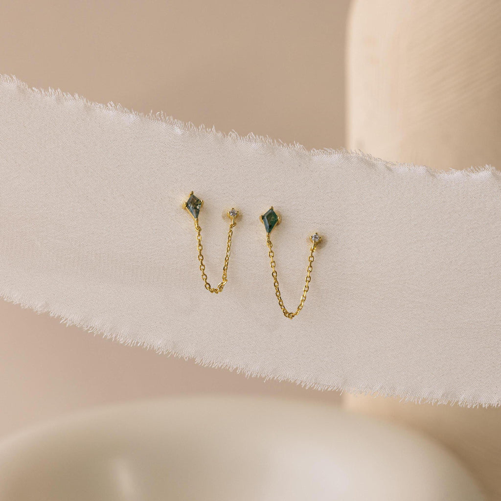 Agate Diamond Chain Earrings featuring green stones and delicate chains, displayed on a textured white fabric background.