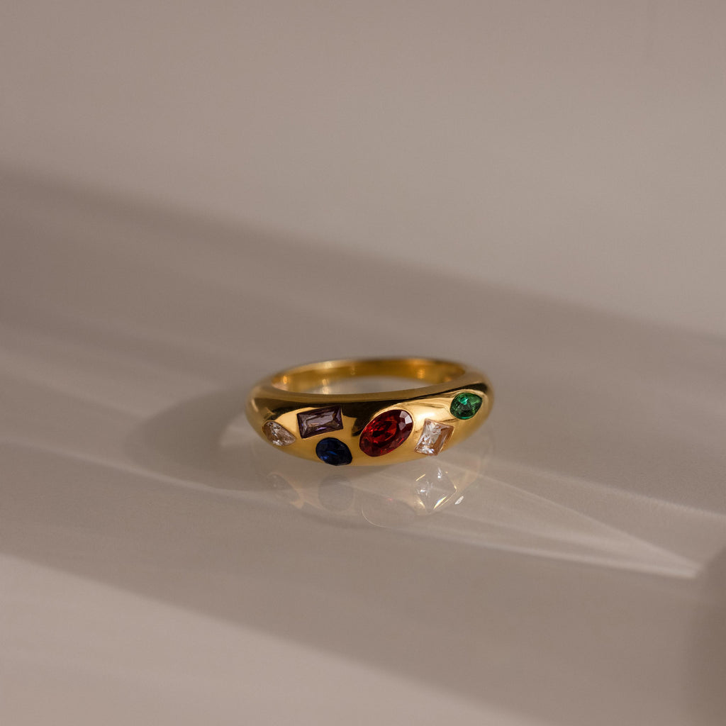 The Mixed Birthstone Dome Ring is a gold ring with customizable red, green, purple, and blue stones on a smooth dome—perfect for personalized jewelry.