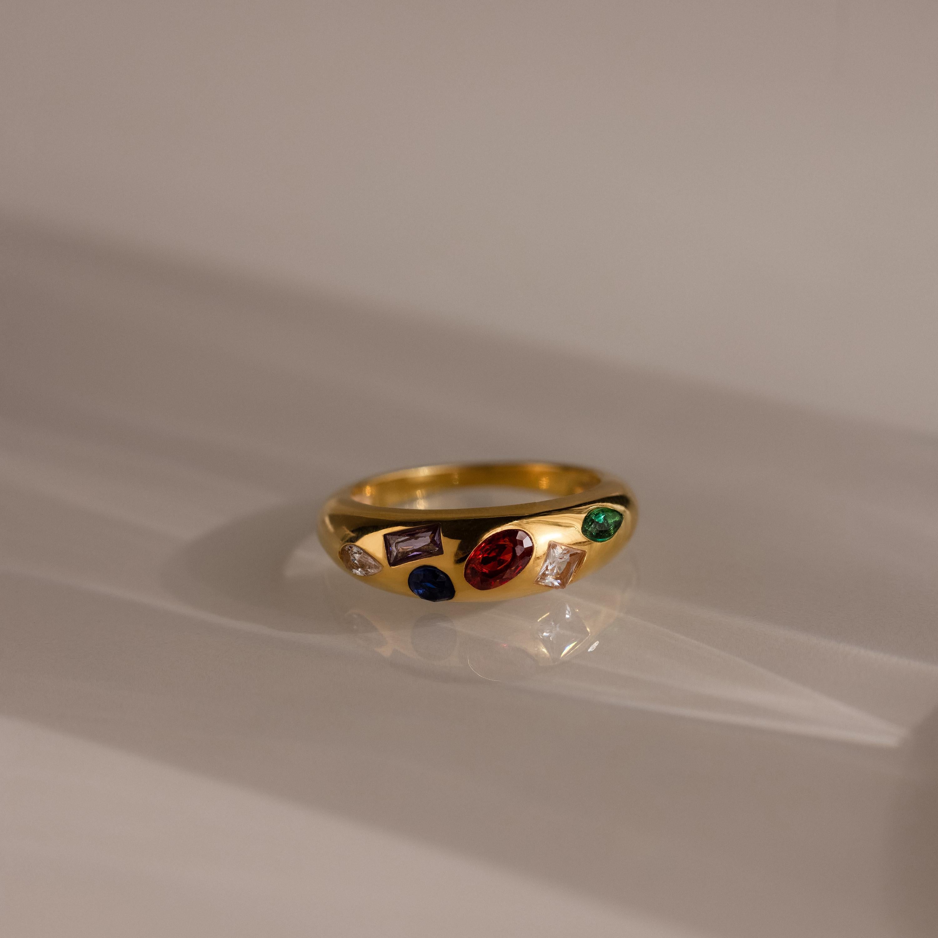 The Mixed Birthstone Dome Ring is a gold ring with customizable red, green, purple, and blue stones on a smooth dome—perfect for personalized jewelry.
