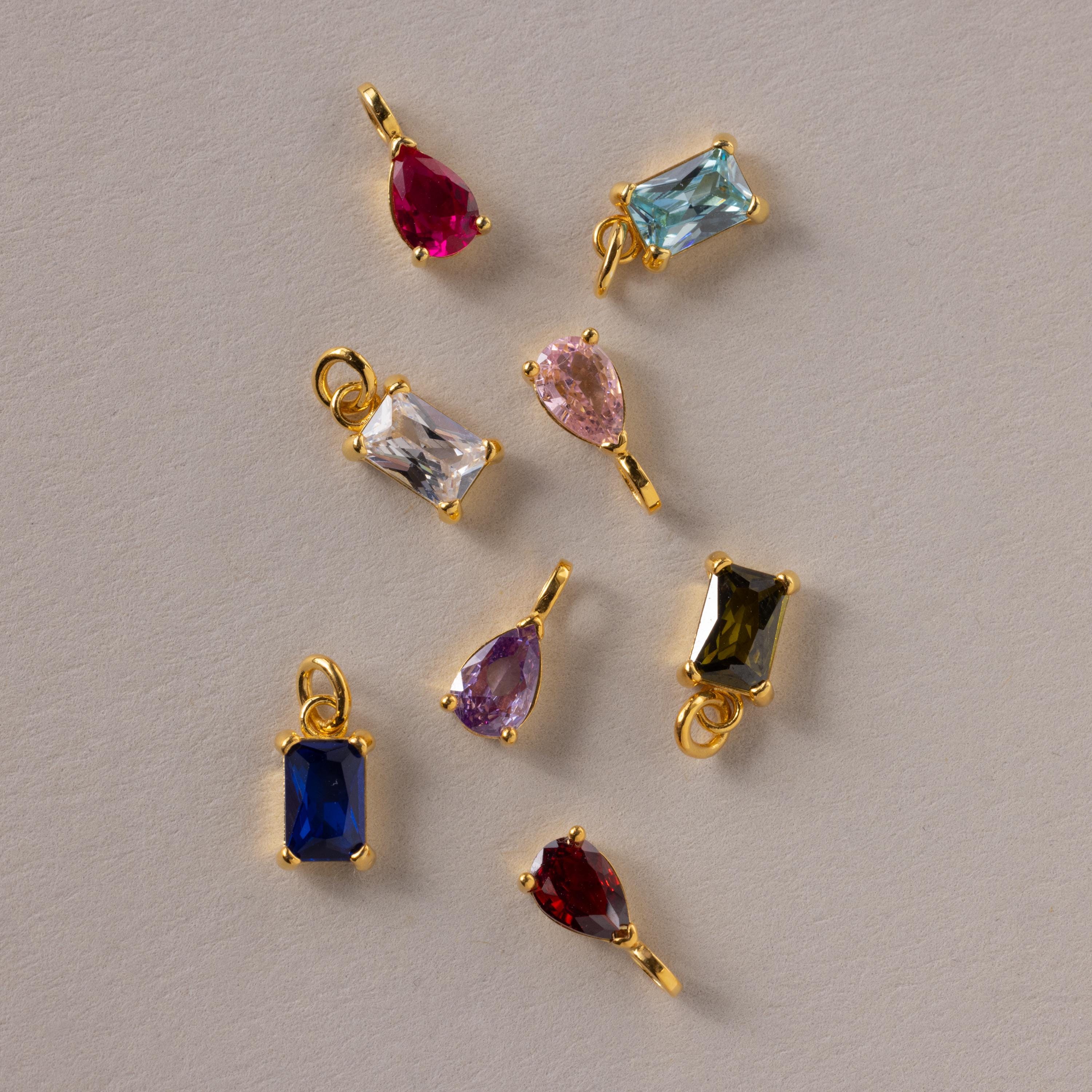 An assortment of Pear & Baguette Birthstone Charms in different stone colors