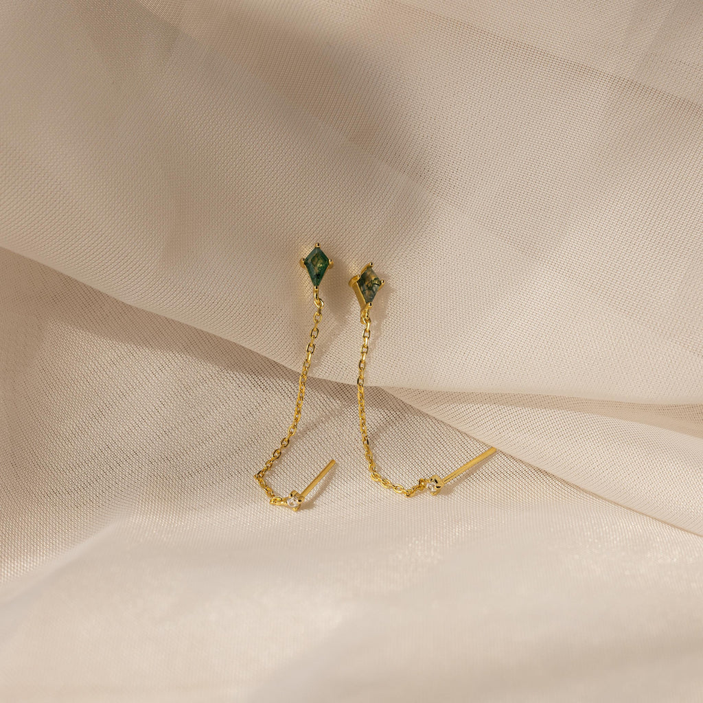 Agate Diamond Chain Earrings with green gemstones and gold chains, showcased on a soft beige fabric background.