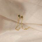 Agate Diamond Chain Earrings with green gemstones and gold chains, showcased on a soft beige fabric background.