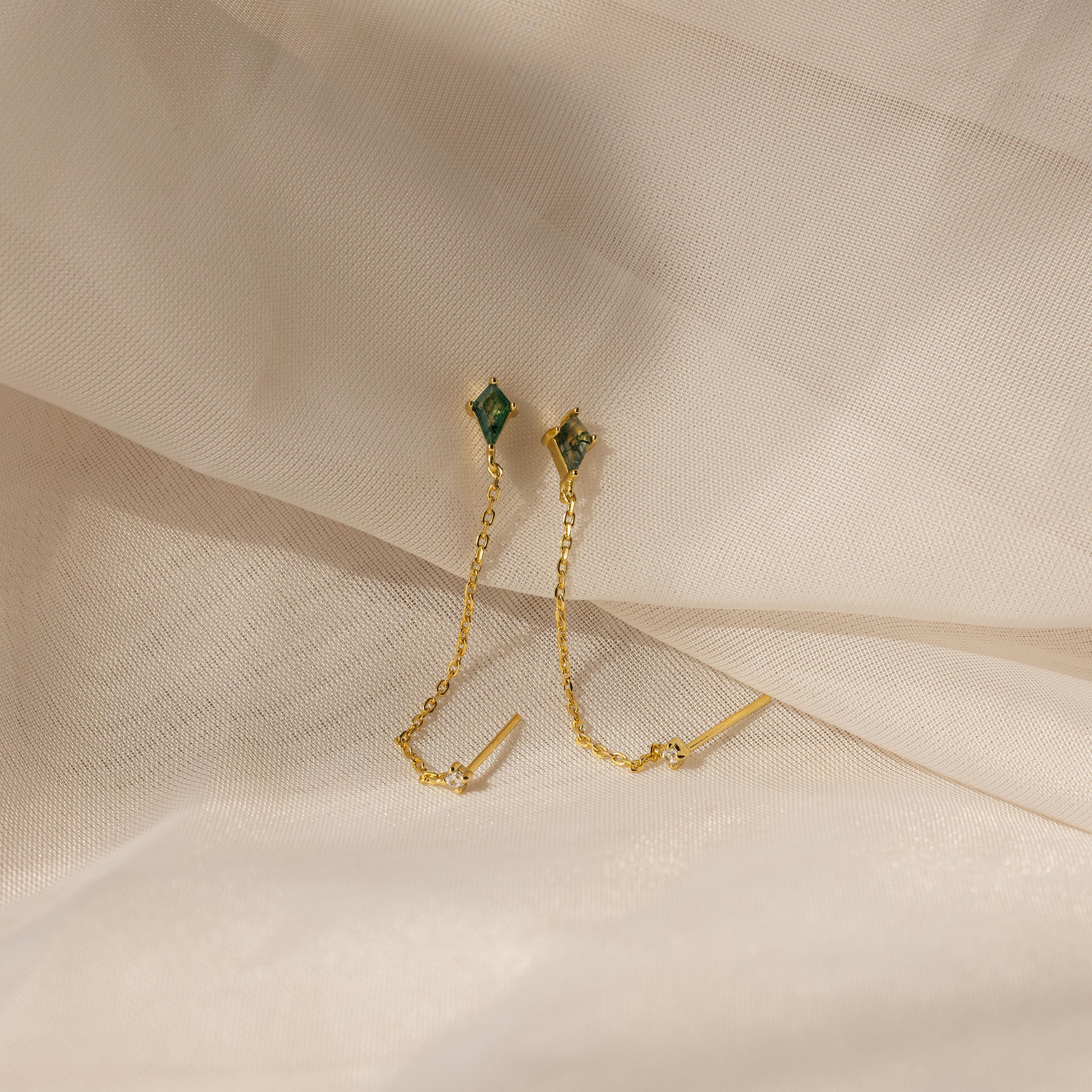 Agate Diamond Chain Earrings with green gemstones and gold chains, showcased on a soft beige fabric background.