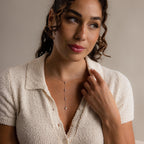 Woman in a textured cream top wears the elegant Mixed Diamond Lariat Necklace, featuring sparkling diamond gemstones, and gazes thoughtfully to the side.