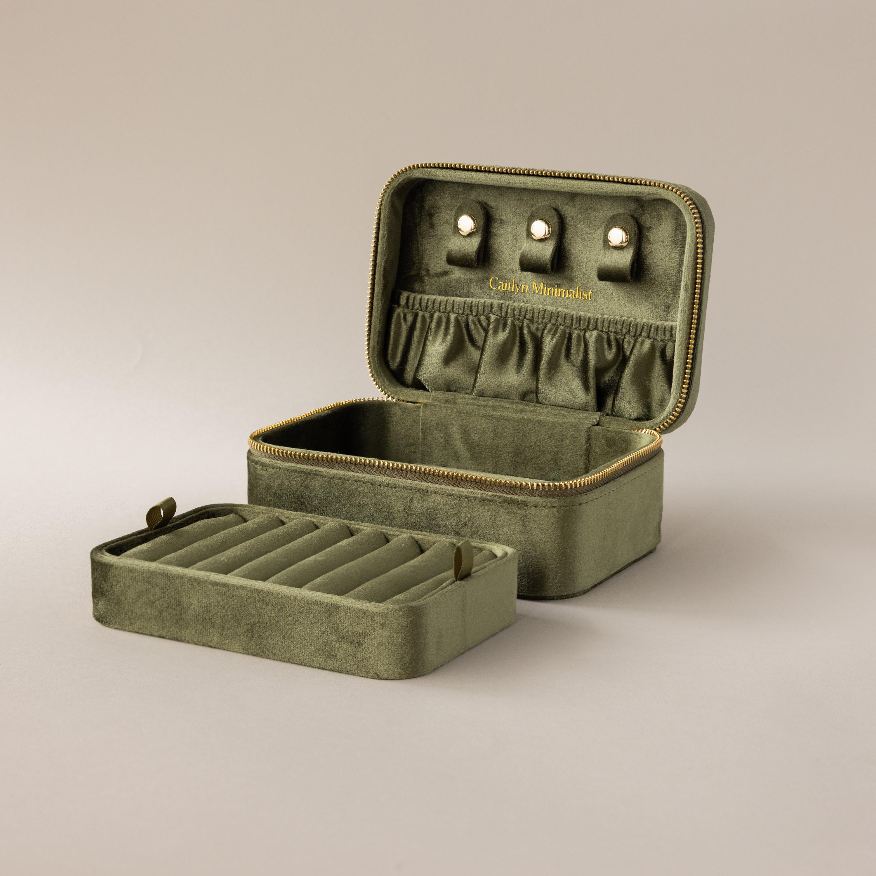 The Rectangle Velvet Jewelry Box in olive green features compartments, ring slots, and earring holders inside its open rectangular design.
