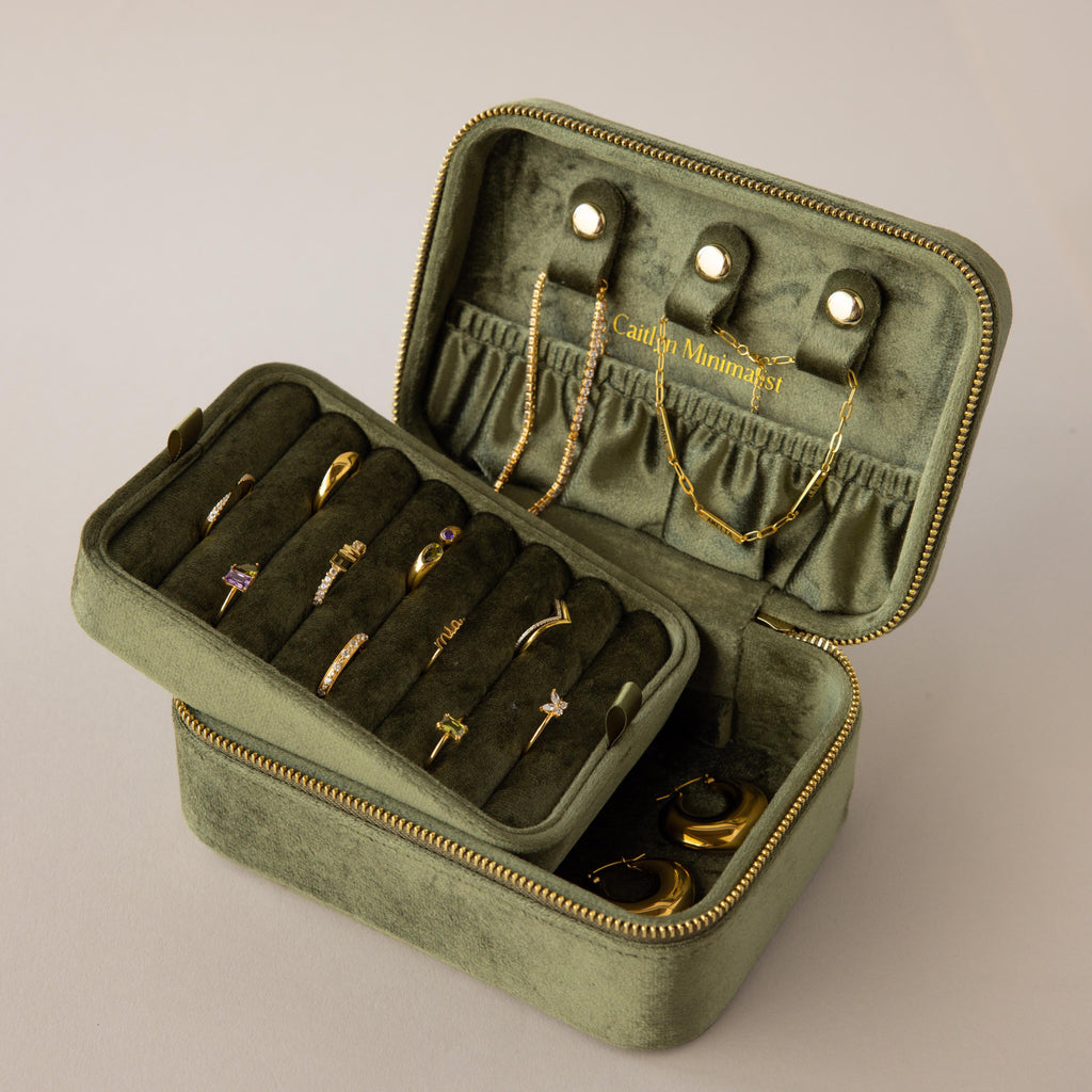 Rectangle Velvet Jewelry Box in green velvet shown open, displaying gold rings, earrings, and necklaces neatly organized inside.