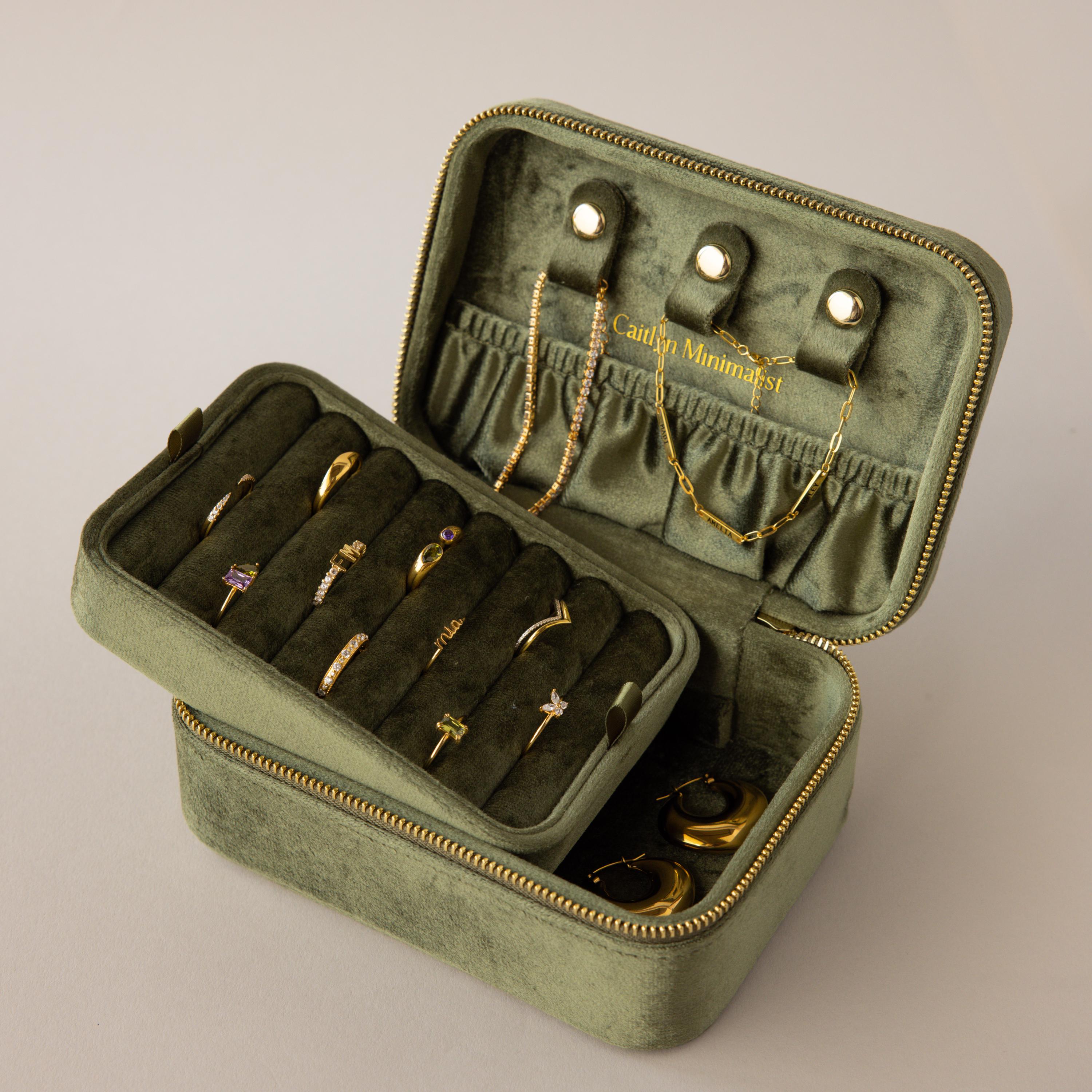 Rectangle Velvet Jewelry Box in green velvet shown open, displaying gold rings, earrings, and necklaces neatly organized inside.