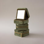 Three Velvet Mirror Jewelry Boxes in green are stacked, with the top box open to reveal a mirror inside its lid.