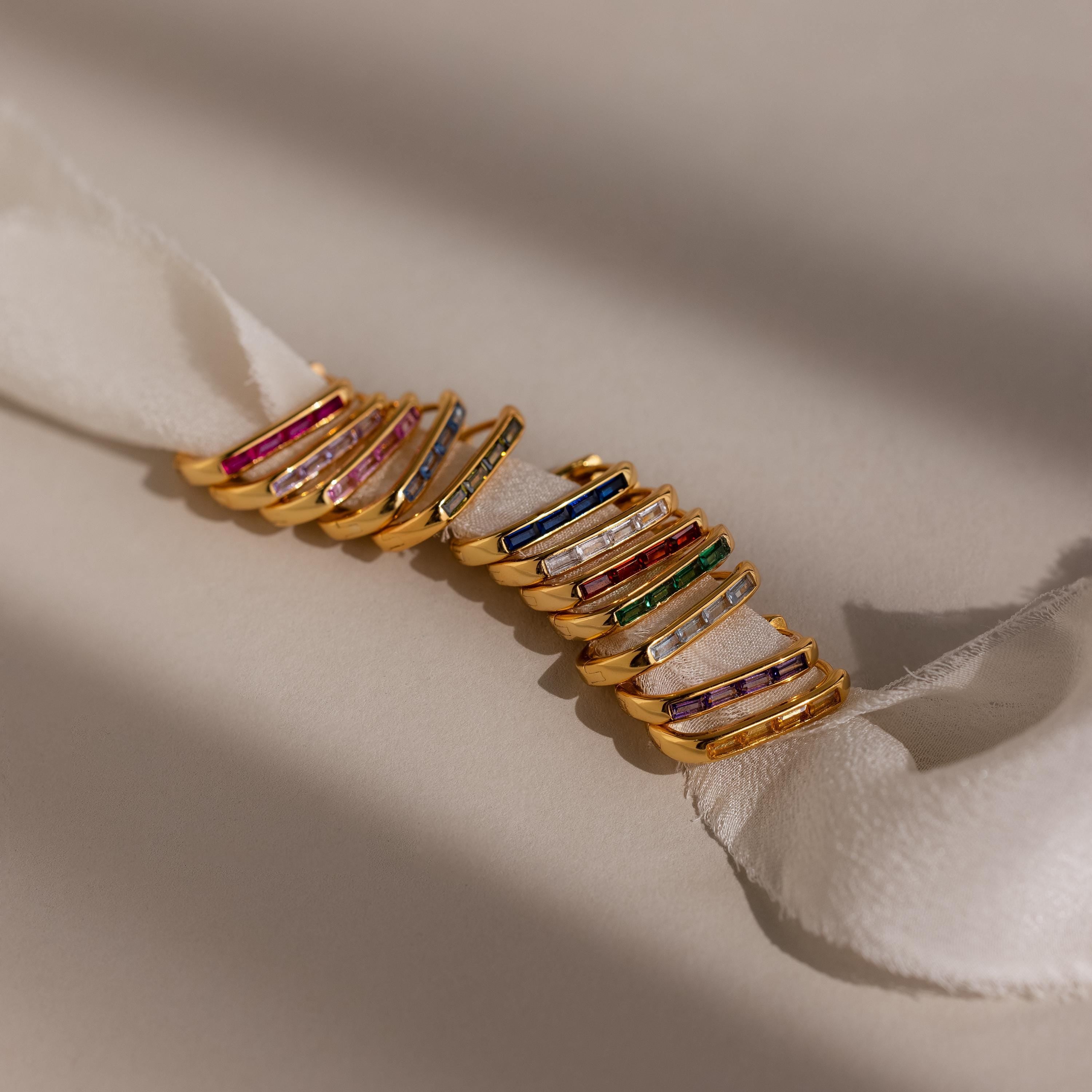 Baguette Birthstone Link Earrings in customizable gemstones and vibrant colors are displayed on a white textured ribbon against a neutral background.