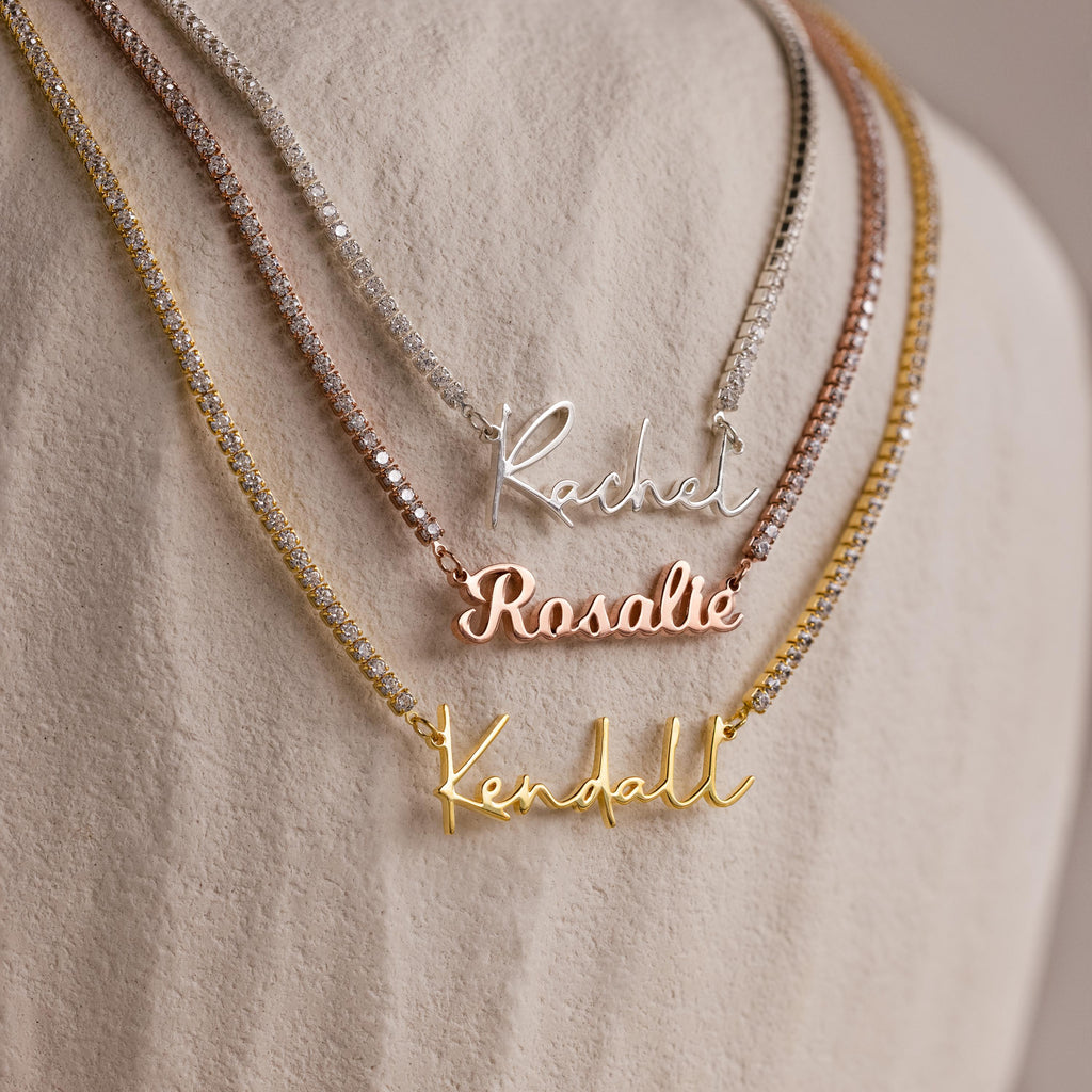 The Diamond Tennis Name Necklace is an elegant piece, available in silver, rose gold, and gold, perfect for custom nameplates like Rachel, Rosalie, and Kendall.