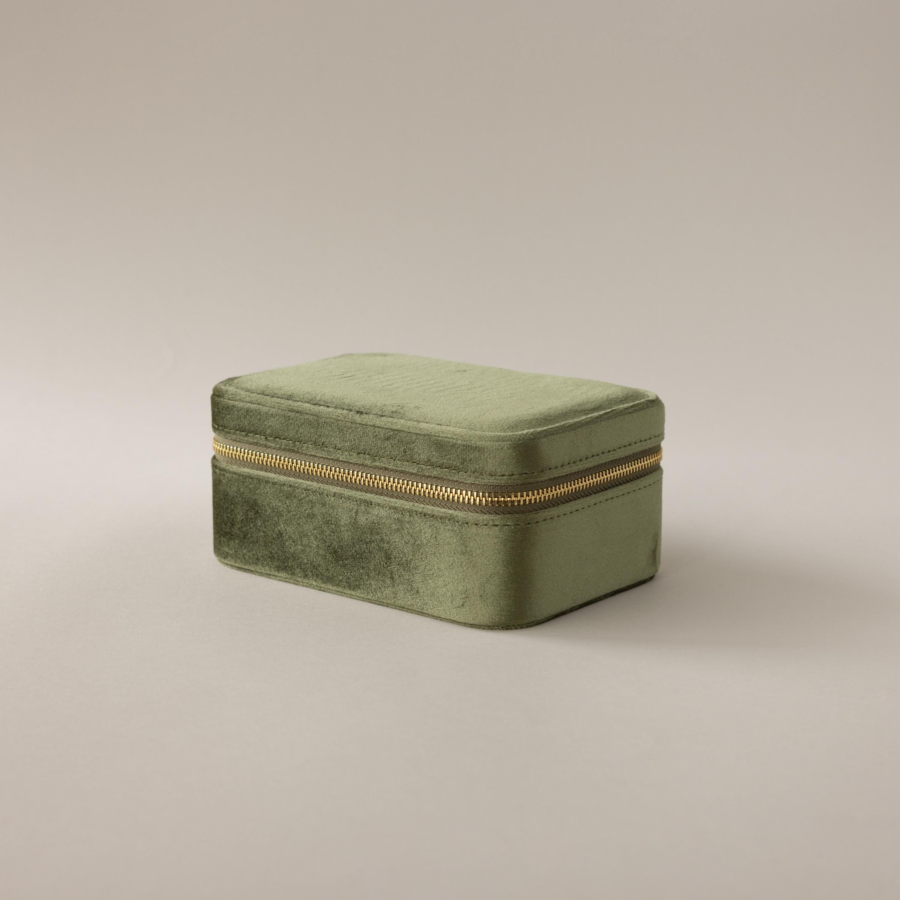 The Rectangle Velvet Jewelry Box in green velvet with a gold zipper is displayed on a plain light background.