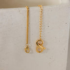 Two 18K gold necklaces from the Multipurpose Lobster Clasp Extender Set, each with a letter A or S pendant, are displayed on a white textured surface. Both feature an adjustable lobster clasp for versatile styling.