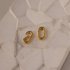 The Multipurpose Charm Hoop Clasp Set in White Gold features two oval charms on a light, textured surface—perfect for stacking bracelets or as a stylish charm connector.