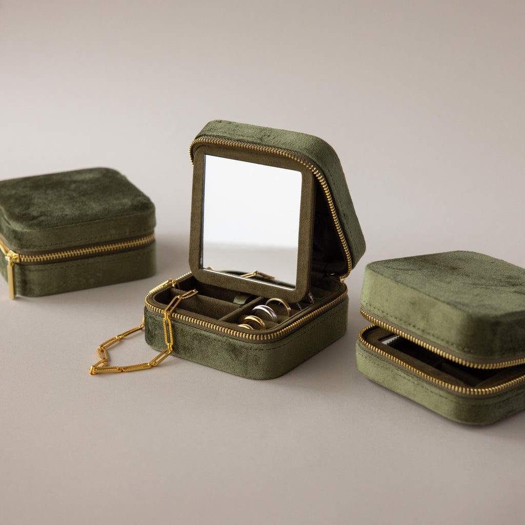 The Velvet Mirror Jewelry Box features green velvet, an interior mirror, and compartments displayed open with rings and a necklace inside.
