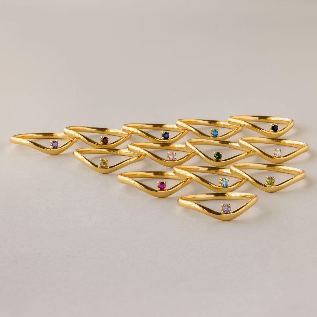 An Amethyst Drop Curve Ring is arranged neatly on a light background.