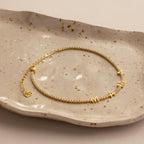 Diamond Tennis Letter Bracelet featuring "MAMA" letter charms and a heart, elegantly displayed on a speckled ceramic dish.