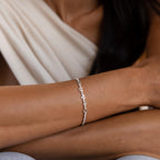 A close-up of a woman's arm wearing the Diamond Tennis Letter Bracelet, featuring small sparkling accents—perfect for those who love a minimalist bracelet style.