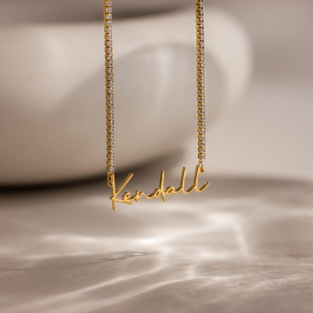 Diamond Tennis Name Necklace with a Kendall pendant, featuring a sparkling diamond tennis chain, displayed on a soft, blurred background.