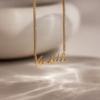 Diamond Tennis Name Necklace with a Kendall pendant, featuring a sparkling diamond tennis chain, displayed on a soft, blurred background.