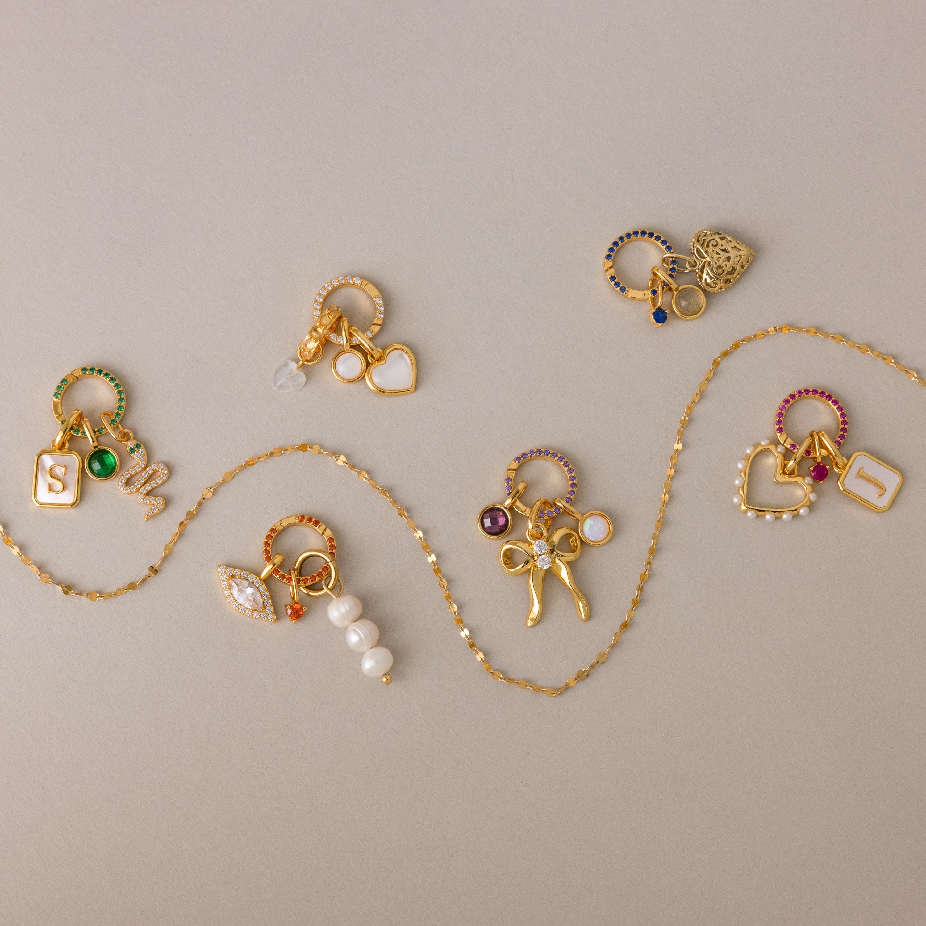 The Pave Peridot Charm Clip features sparkling gemstones on gold, ideal for personalizing jewelry or adding a unique birthstone accent to your collection.