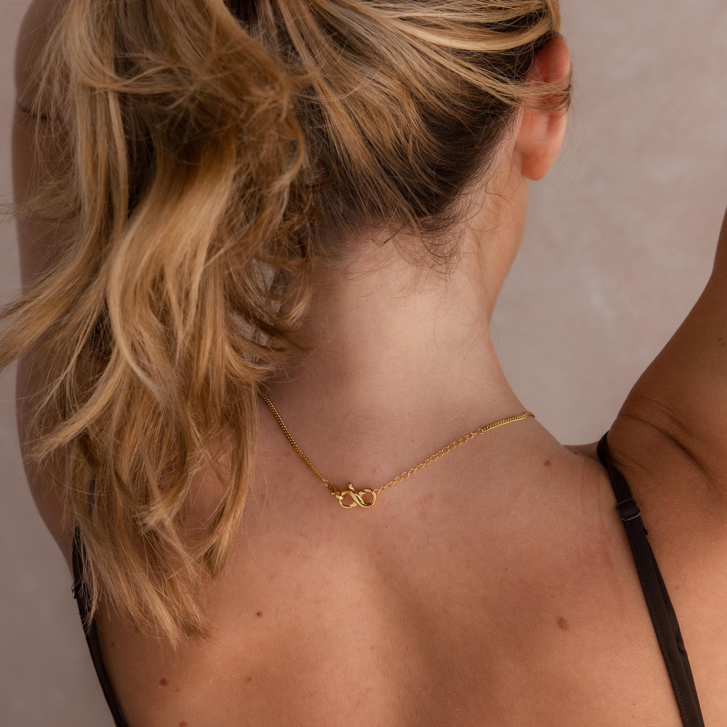 Woman with blonde ponytail, seen from behind, wears a Multipurpose Lobster Clasp Extender Set in White Gold and a black strap top.