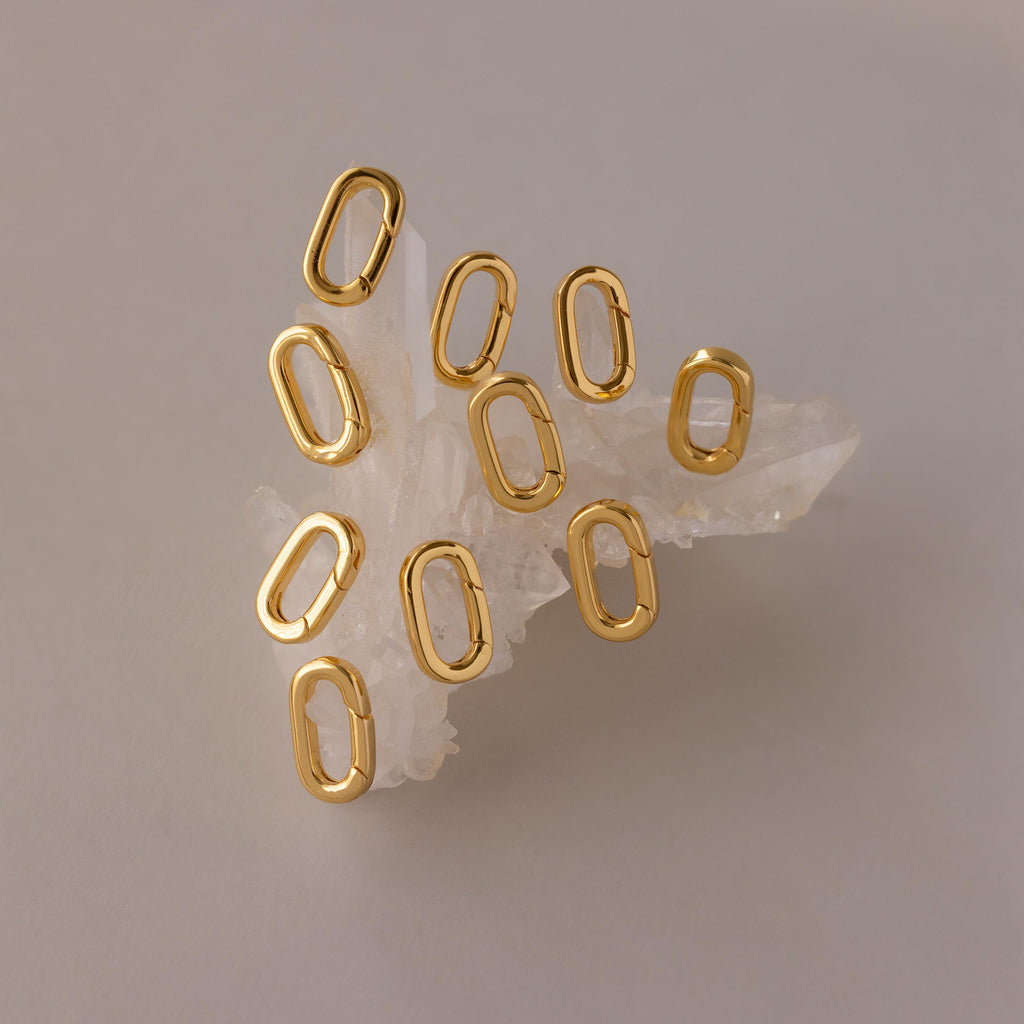 The Multipurpose Charm Hoop Clasp Set in 18K Gold features oval links on clear quartz, ideal for bracelet stacking or as a versatile connector in your jewelry designs.