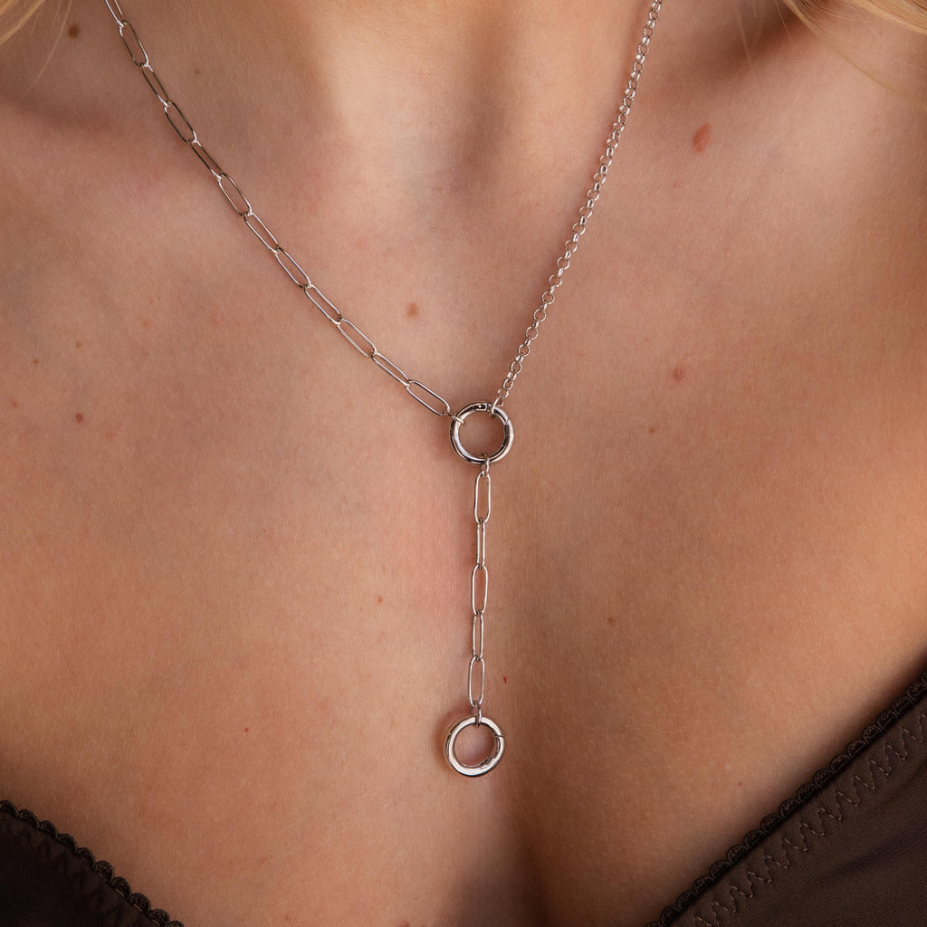 Close-up of a silver Rolo Lariat Paperclip Clasp Necklace with two interlocking circles, worn on a woman's neck.
