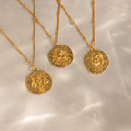 Libra, Sagittarius and Pisces hammered Zodiac Gemstone Coin Necklaces lay side by side.