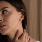 Wide view of model wearing Gold Star Drop Chain Earrings