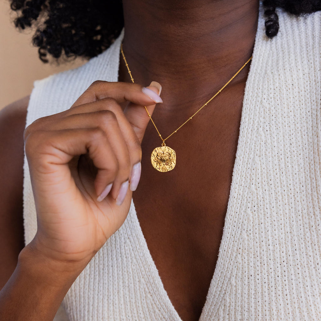 Model wears a gold cancer Zodiac Gemstone Coin Necklace on satellite chain