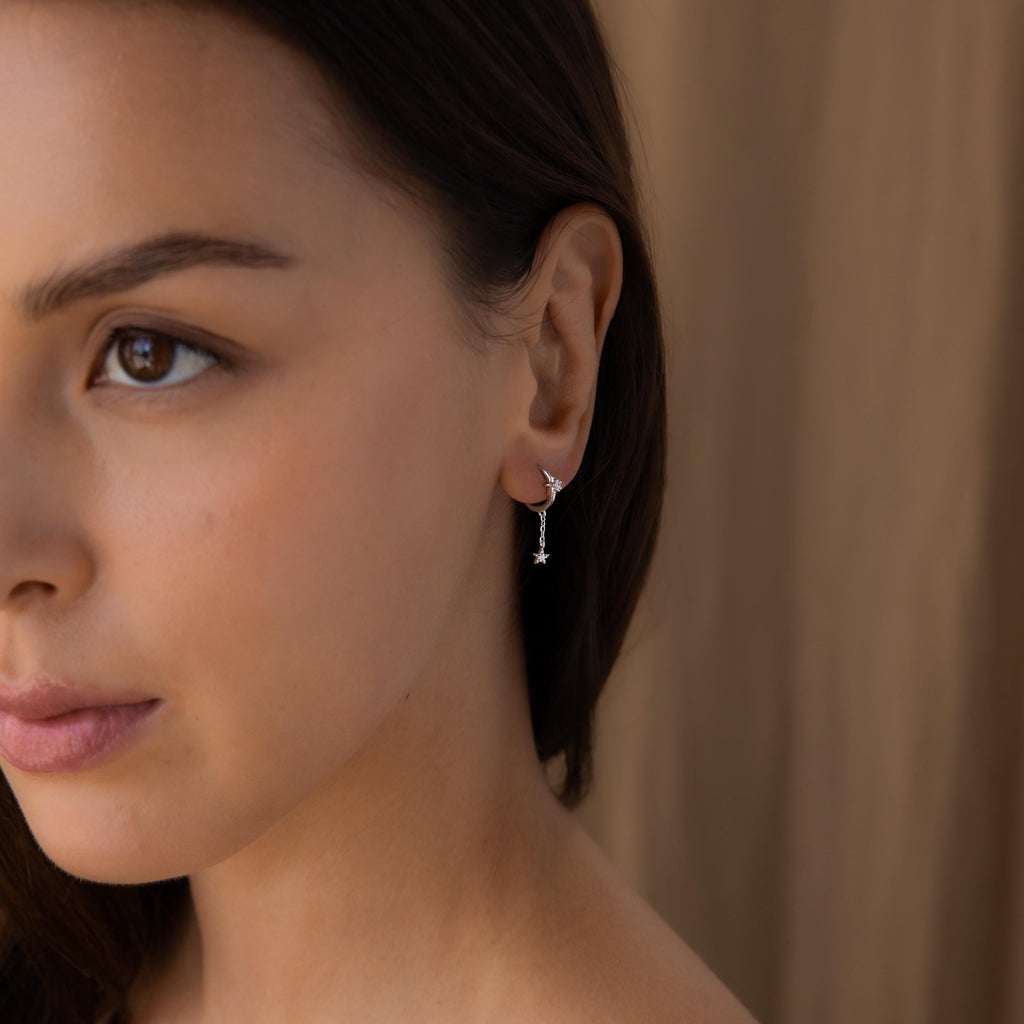 Wide view of model wearing Silver Star Drop Chain Earrings