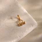 A single Libra zodiac charm pendant rests on a stone background