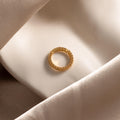 The Pave Topaz Charm Clip, adorned with sparkling gems and displayed on soft cream fabric, is the perfect accent for your personalized jewelry or charm holder.