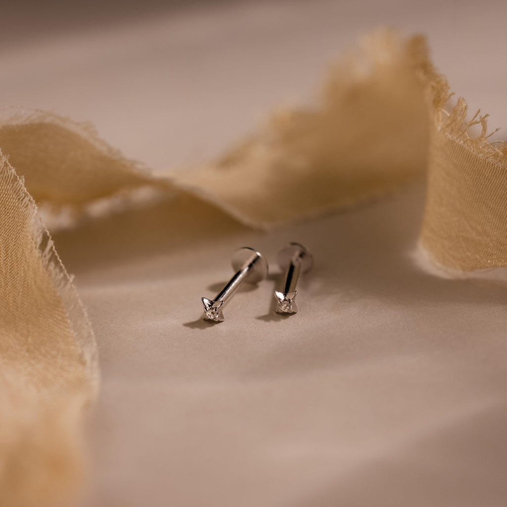 Close up of silver North Star Stud Earrings with flat backs. The earrings feature a north star design with a diamond earring in the middle