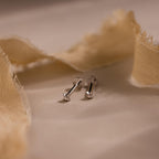 Close up of silver North Star Stud Earrings with flat backs. The earrings feature a north star design with a diamond earring in the middle