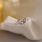 Close up of set of 3 silver mismatched CZ Diamond Constellation Stud Earrings resting on a ceramic dish