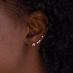 Close up of model wearing an earring stack of 3 dainty gold CZ Diamond Constellation Studs