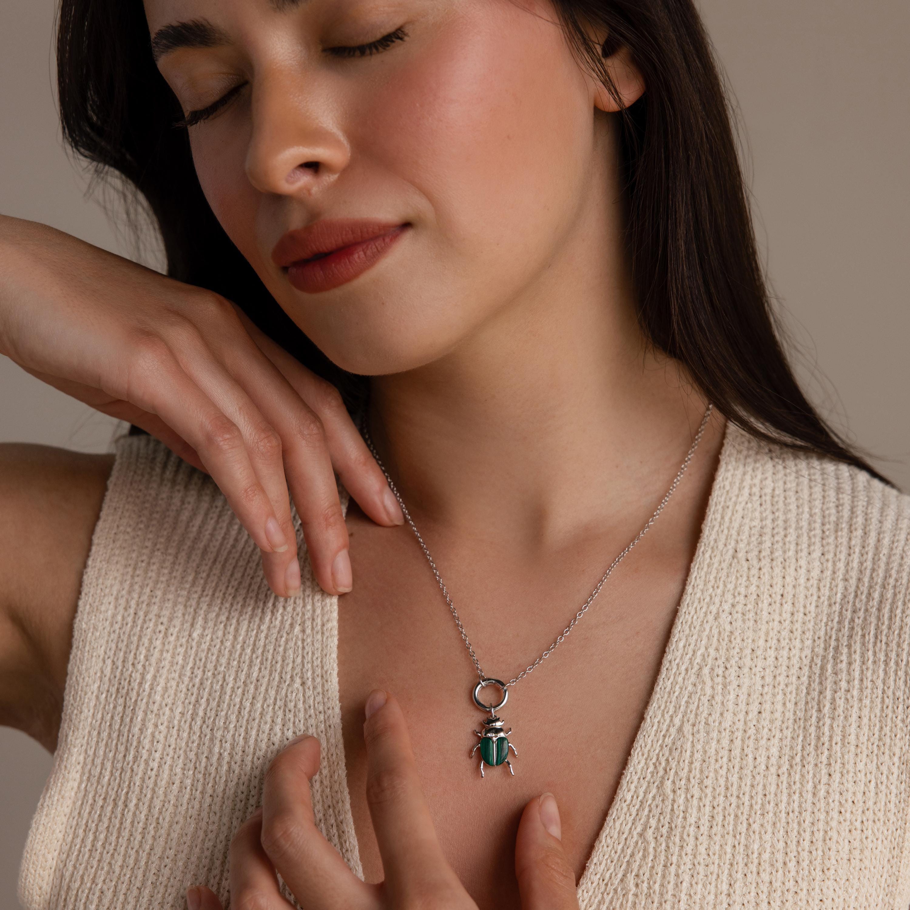 A front-facing view of a model wearing a silver chain with the silver Malachite Beetle Charm hanging from a Rolo Circle Necklace.