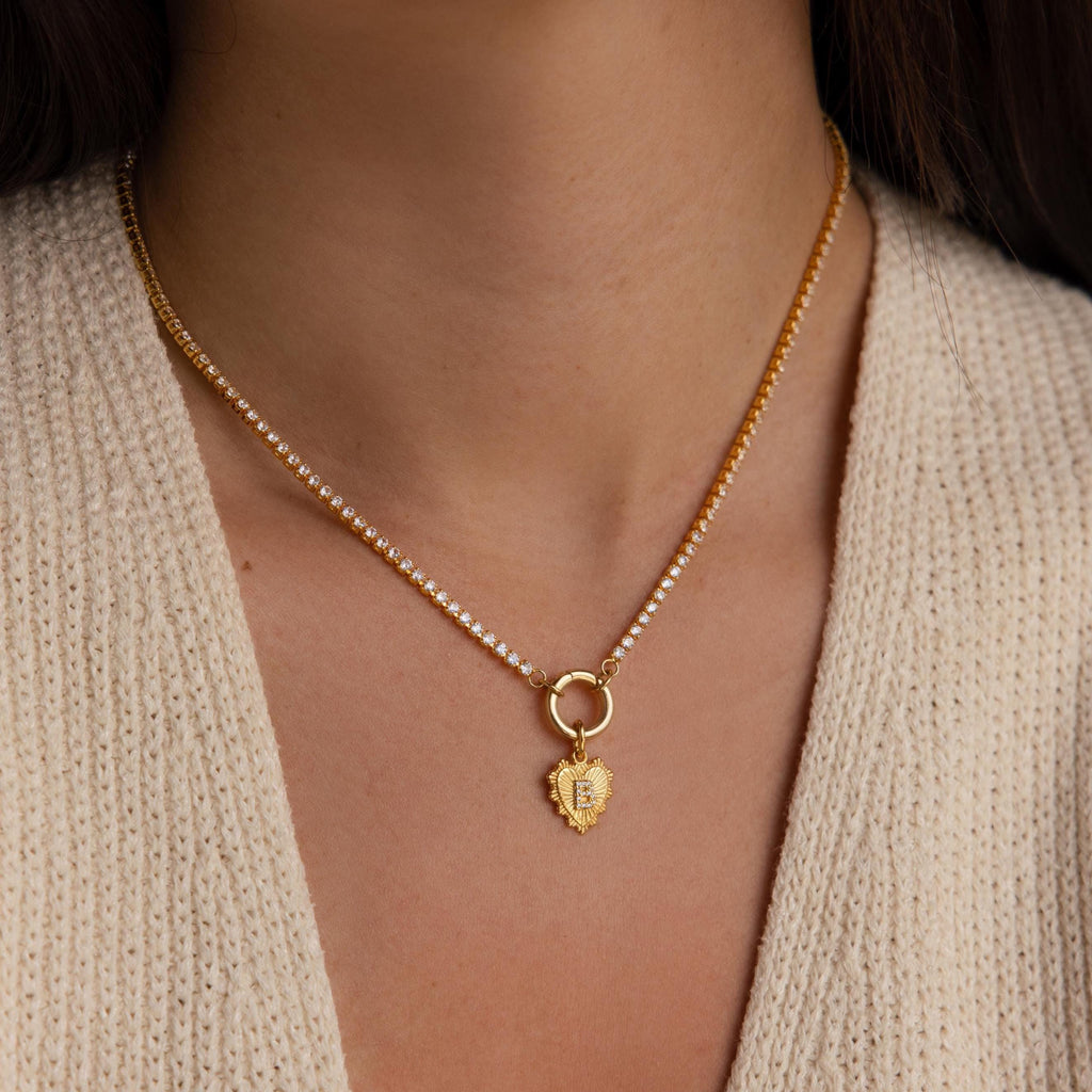 Model wearing the Ribbed Heart Initial Pendant on a Rolo Circle Necklace, styled with a sparkling tennis-style chain, showcasing the charm resting at the collarbone.
