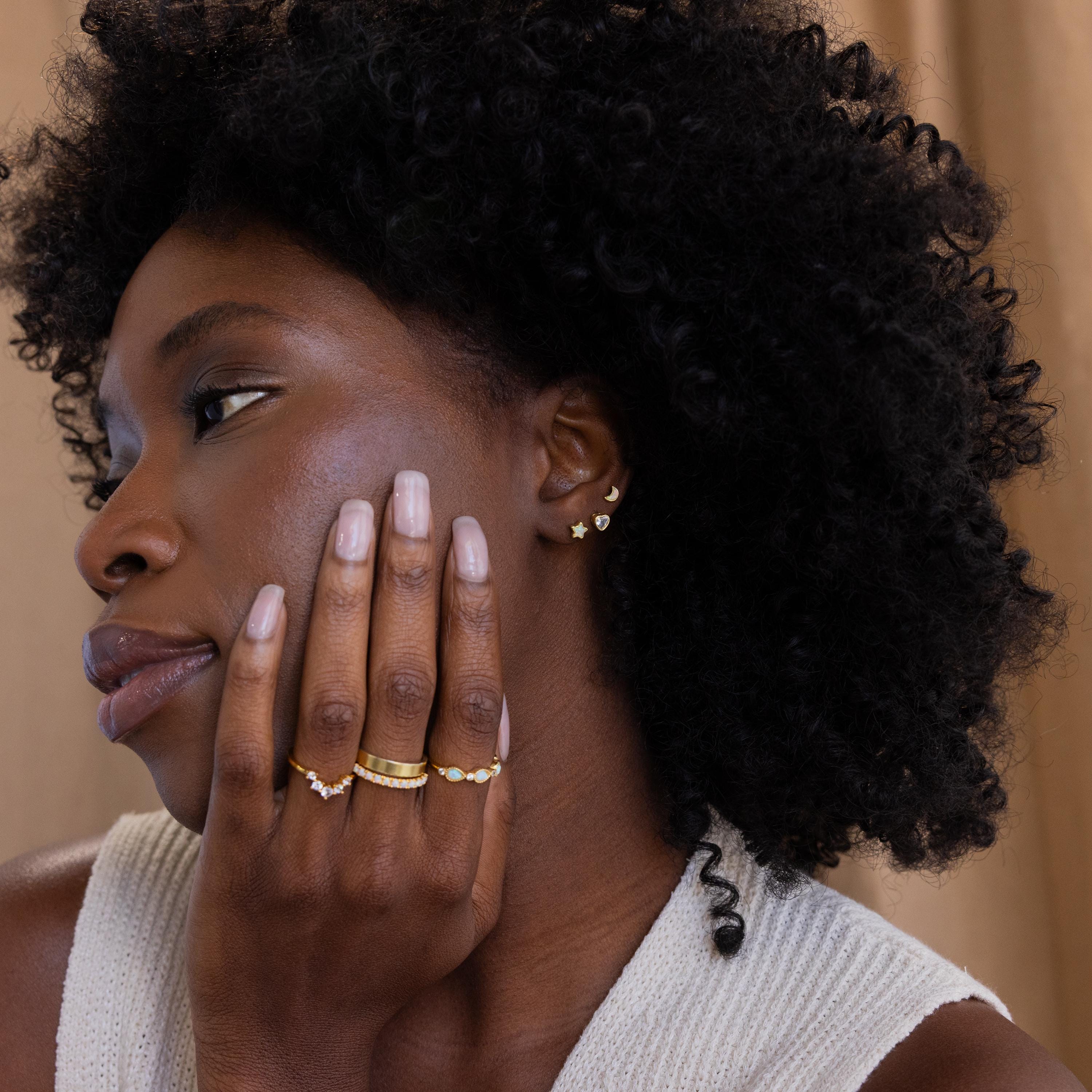 Model wearing stacked set of 3 opal moon, CZ diamond heart, and opal star Celestial Stud Earrings with opal and diamond stacking rings