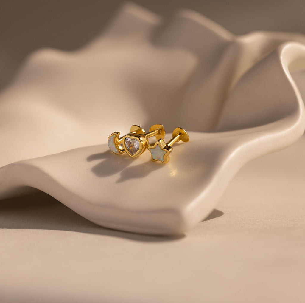 Flat lay of Celestial Opal and CZ Diamond Flat Back Earring 3 Piece Set in Gold.