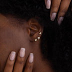 Close up of model wearing Celestial Flat Back Earring 3 Piece Set in gold. Features opal star, cz diamond heart, and opal moon