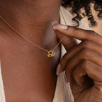 Gold CZ diamond Libra Zodiac Charm Necklace hanging delicately from model's neck.