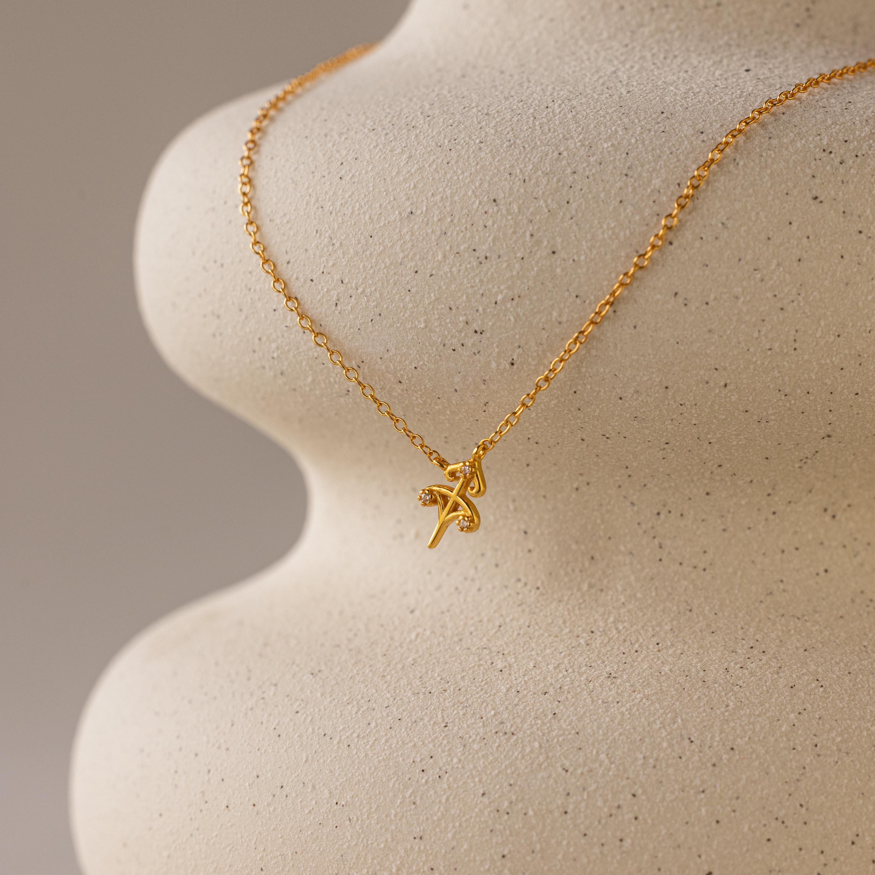 Gold CZ diamond dainty Sagittarius Zodiac Charm Necklace hanging from vase.