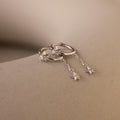 A pair of Silver Star Drop Chain Earrings laying side by side