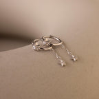 A pair of Silver Star Drop Chain Earrings laying side by side