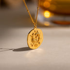 Close up of a Gold 3D Pisces Zodiac Coin Pendant Necklace with small CZ gemstones, attached to a dainty satellite chain.