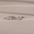 Silver Pavé Viper Huggie Earrings placed on a neutral-toned background