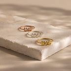 Three Bubble Numbers Rings in rose gold, silver, and gold read “1991,” “2006,” and “1995” on a neutral slab surface.